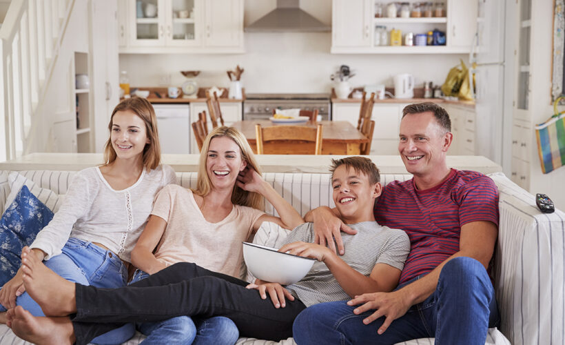 Familia compartiendo en la sala de su casa en Canadá.